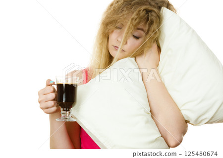 Tired woman drinking her morning coffee Tired woman drinking her morning coffee 125480674