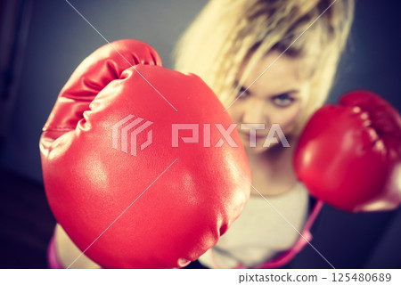 Angry woman wearing boxing gloves 125480689