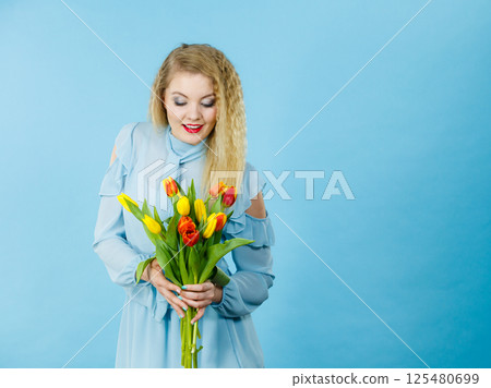 Pretty woman with red yellow tulips bunch Pretty woman with red yellow tulips bunch 125480699