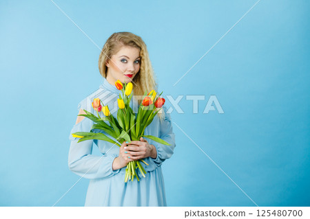 Pretty woman with red yellow tulips bunch 125480700