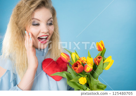 Woman holds tulips and red heart Woman holds tulips and red heart 125480705