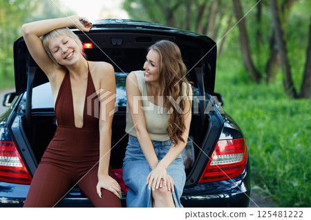 Two woman drivers at car smiling. Cute young happy female driving car vehicle Two woman drivers at car smiling. Cute young happy female driving car vehicle 125481222