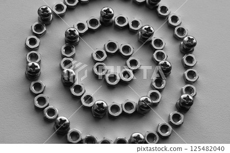Pattern of perfect rings made of nuts with bolts screwed into them monochrome stock photo for mechanical backgrounds 125482040