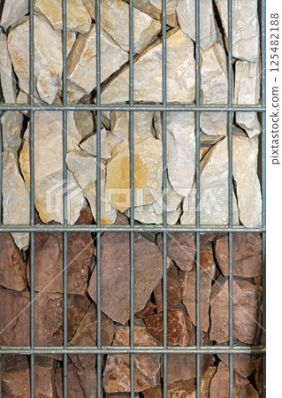 Stone piles inside metal cage 125482188