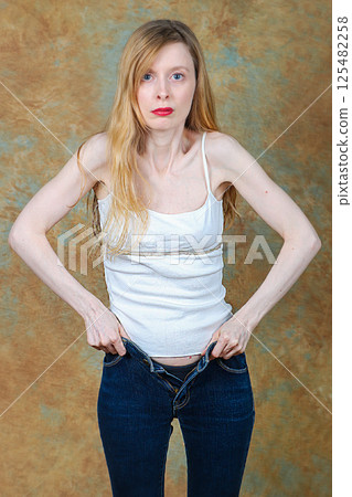 Woman putting on and fastening skinny jeans 125482258