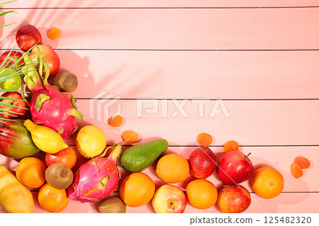 Dragon fruit, pitaya, mango, kiwi, avacado, apples, citrus fruits and dried apricots on a sunny table. Healthy vegan food for weight loss. Banner with tropical exotic fruits and juice. 125482320