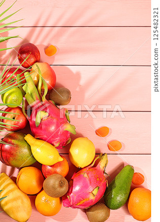 Healthy vegan food for weight loss. Banner with tropical exotic fruits and juice. Dragon fruit, pitaya, mango, kiwi, avacado, apples, citrus fruits and dried apricots on a sunny table. Healthy vegan food for weight loss. Banner with tropical exotic fruits and juice. Dragon fruit, pitaya, mango, kiwi, avacado, apples, citrus fruits and dried apricots on a sunny table. 125482321