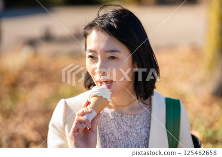 中年婦女在旅遊景點吃軟冰淇淋 125482658