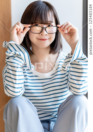 一位戴眼鏡的年輕女子在房間裡休息 125483184