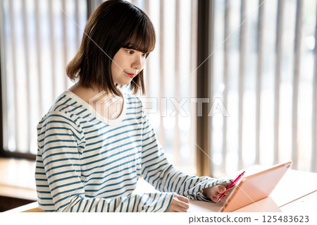 Young woman studying using a tablet 125483623