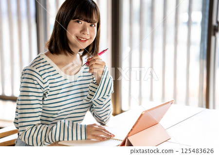 Young woman studying using a tablet 125483626