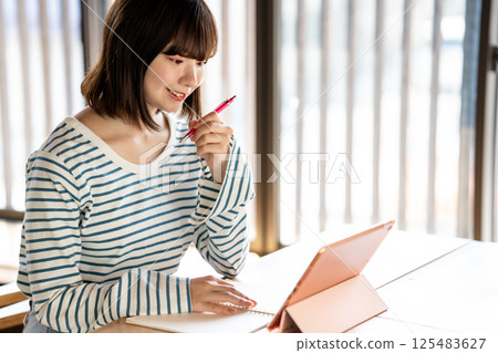 Young woman studying using a tablet 125483627
