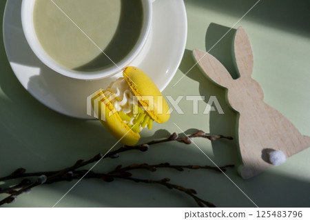 Happy Easter wooden bunny rabbit decoration Sweet macaron dessert Cup of green plant based matcha tea latte in cozy morning atmosphere. Creative holiday romantic date idea. Herbal prebiotic fiber 125483796