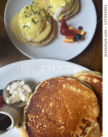 Classic Brunch Spread with Eggs Benedict, Pancakes, and Fresh Fruit Sides 125484801