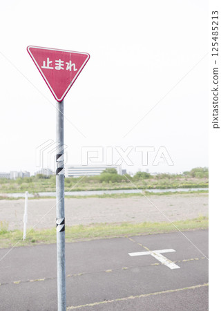 Caution: Stop sign for cars at a T-junction on the riverbed. Photo of a stop sign 125485213