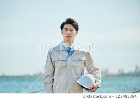A young man in his 20s wearing work clothes 125485384