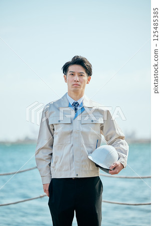 A young man in his 20s wearing work clothes 125485385
