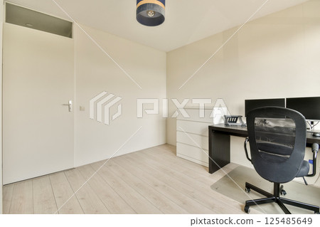 A clean and minimalistic office interior featuring a desk, chair, and neutral wall colors. Perfect for a workspace aesthetic. 125485649