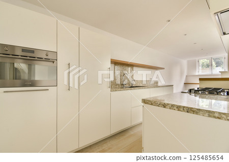 A contemporary kitchen featuring sleek cabinetry, elegant countertops, and a well-organized layout, perfect for culinary creations and gatherings. A contemporary kitchen featuring sleek cabinetry, elegant countertops, and a well-organized layout, perfect for culinary creations and gatherings. 125485654