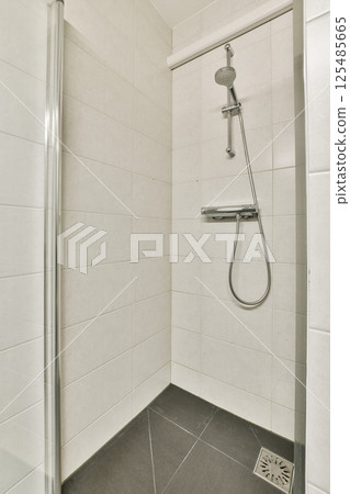 A sleek and contemporary shower area showcasing clean lines and neutral tones, designed for functionality and simplicity in a modern bathroom. 125485665