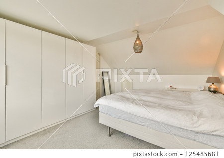 A contemporary bedroom featuring sleek furniture, soft bedding, and stylish lighting that creates a tranquil atmosphere for relaxation and rest. A contemporary bedroom featuring sleek furniture, soft bedding, and stylish lighting that creates a tranquil atmosphere for relaxation and rest. 125485681