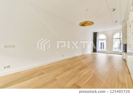 A bright and airy room featuring wooden flooring, high ceilings, and large windows that let in natural light, creating an inviting and open atmosphere. A bright and airy room featuring wooden flooring, high ceilings, and large windows that let in natural light, creating an inviting and open atmosphere. 125485720