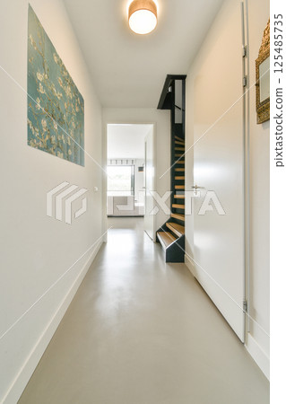 A contemporary indoor space featuring minimalistic decor, a striking wall art piece, and clear lines leading to an inviting room. A contemporary indoor space featuring minimalistic decor, a striking wall art piece, and clear lines leading to an inviting room. 125485735