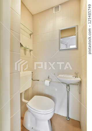 A contemporary bathroom featuring minimalist design elements, neutral tiles, and functional fixtures for efficient space utilization. 125485749