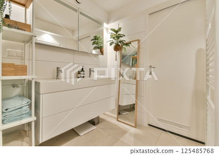 A sleek, modern bathroom featuring elegant fixtures, a large mirror, and stylish decor, creating a serene and inviting atmosphere. A sleek, modern bathroom featuring elegant fixtures, a large mirror, and stylish decor, creating a serene and inviting atmosphere. 125485768