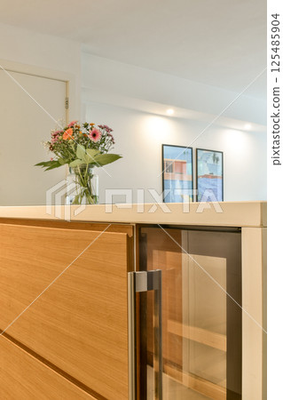 Stylish kitchen featuring elegant cabinetry and a decorative vase with flowers, creating a warm and inviting atmosphere. Stylish kitchen featuring elegant cabinetry and a decorative vase with flowers, creating a warm and inviting atmosphere. 125485904