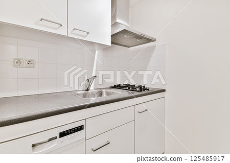 a kitchen with white cabinets and black counter tops on the counters in front of the dishwasher there is an appliance 125485917