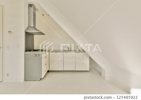 Sleek modern kitchen featuring minimalist design elements, light colors, and a well-organized layout. Ideal for contemporary living spaces. 125485922