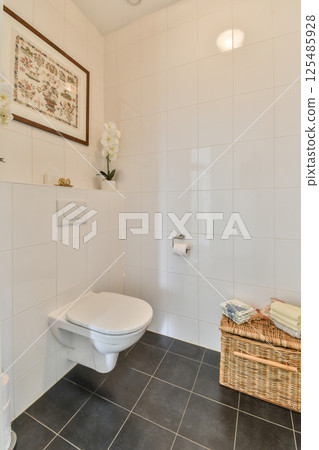 Contemporary bathroom showcasing stylish tiles, a sleek toilet, and tasteful decor. A perfect blend of functionality and aesthetic appeal. 125485928