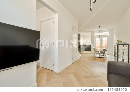 A bright and spacious modern interior showcases minimalist decor with wooden flooring and contemporary furniture, creating a warm and inviting atmosphere. A bright and spacious modern interior showcases minimalist decor with wooden flooring and contemporary furniture, creating a warm and inviting atmosphere. 125485950