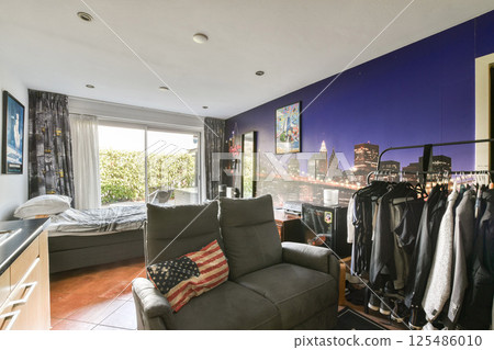 A stylish living area featuring a captivating cityscape wall art, modern furniture, and a bright window, creating a welcoming atmosphere. 125486010