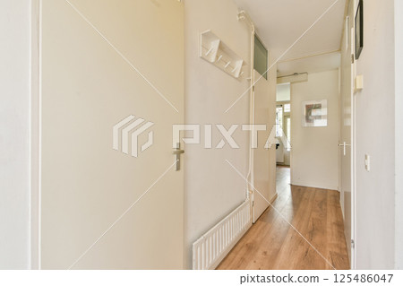 A sleek and modern hallway featuring clean lines, white walls, and wooden flooring, creating a bright and inviting atmosphere. A sleek and modern hallway featuring clean lines, white walls, and wooden flooring, creating a bright and inviting atmosphere. 125486047
