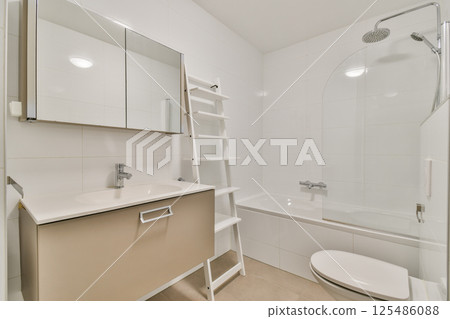Sleek and contemporary bathroom featuring a bathtub, shower, mirror, and minimalist storage, creating a clean and welcoming atmosphere. Sleek and contemporary bathroom featuring a bathtub, shower, mirror, and minimalist storage, creating a clean and welcoming atmosphere. 125486088