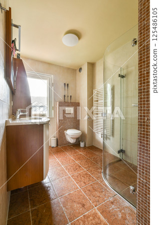 Contemporary bathroom featuring elegant tiles, a glass shower, modern fixtures, and a bright atmosphere. Ideal for showcasing stylish interiors. 125486105