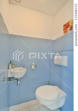 A clean, modern bathroom featuring light blue tiles, minimalistic fixtures, and simple design elements creating a tranquil space. A clean, modern bathroom featuring light blue tiles, minimalistic fixtures, and simple design elements creating a tranquil space. 125486155