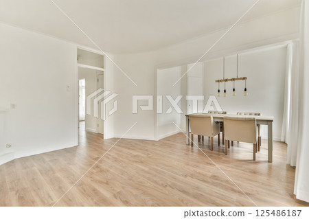 A contemporary dining space featuring a light wood floor, elegant furniture, and tasteful lighting, promoting a welcoming ambiance for gatherings. A contemporary dining space featuring a light wood floor, elegant furniture, and tasteful lighting, promoting a welcoming ambiance for gatherings. 125486187