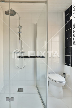 A contemporary bathroom featuring a sleek glass shower enclosure, minimalist design, and clean lines. The bright space emphasizes modern aesthetics and functionality. A contemporary bathroom featuring a sleek glass shower enclosure, minimalist design, and clean lines. The bright space emphasizes modern aesthetics and functionality. 125486228
