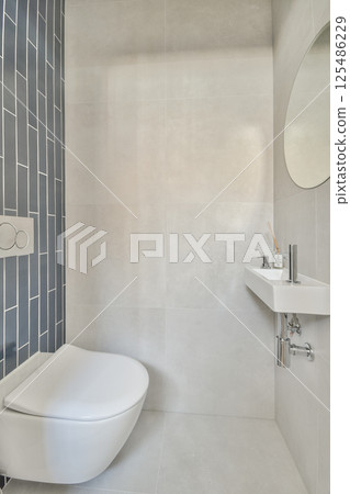 A sleek and minimalist bathroom featuring elegant tiles, a modern toilet, and stylish fixtures designed for comfort and aesthetics. A sleek and minimalist bathroom featuring elegant tiles, a modern toilet, and stylish fixtures designed for comfort and aesthetics. 125486229