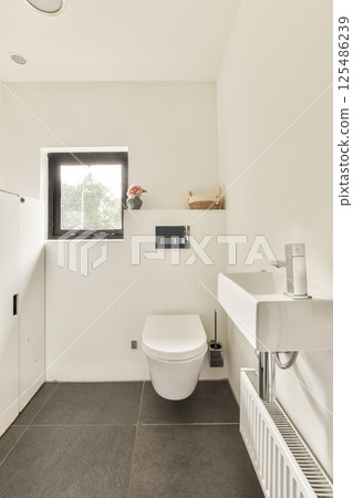 A sleek and modern bathroom featuring a minimalist aesthetic with clean lines, a white color palette, and functional fixtures for a contemporary look. A sleek and modern bathroom featuring a minimalist aesthetic with clean lines, a white color palette, and functional fixtures for a contemporary look. 125486239