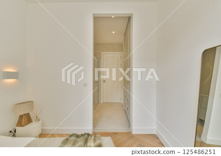 Elegant and spacious minimalist bedroom featuring soft lighting, neutral tones, and simple decor. The layout emphasizes comfort and tranquility. 125486251