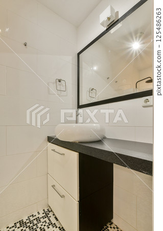 Featuring sleek tiles and a minimalist vanity, this bathroom space showcases contemporary design aesthetics and functional elegance. 125486263