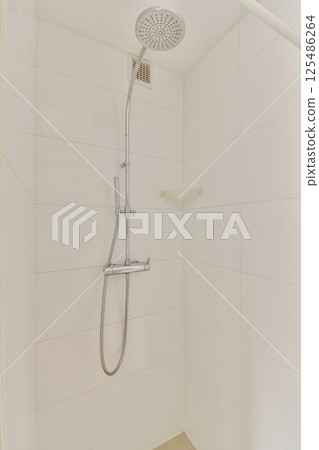 A sleek and contemporary shower setup featuring a modern showerhead and minimalistic design elements, ideal for a luxurious bathing experience. 125486264