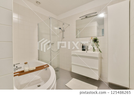 A stylish modern bathroom featuring a shower, bathtub, and sleek storage solutions, accentuated by minimalist decor and neutral tones. 125486265
