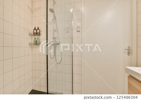 A sleek and contemporary shower room featuring a glass enclosure, minimalist design, and light-colored tiles for a clean, spacious feel. A sleek and contemporary shower room featuring a glass enclosure, minimalist design, and light-colored tiles for a clean, spacious feel. 125486304