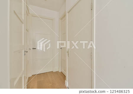 A sleek and modern hallway featuring clean lines and a neutral color palette. The design emphasizes simplicity and elegance in interior architecture. A sleek and modern hallway featuring clean lines and a neutral color palette. The design emphasizes simplicity and elegance in interior architecture. 125486325