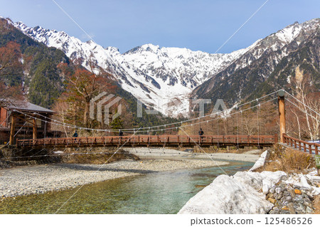 Quiet Kamikochi in spring before the mountain opens. Kappa Bridge, the Hotaka mountain range, and the Azusa River. Quiet Kamikochi in spring before the mountain opens. Kappa Bridge, the Hotaka mountain range, and the Azusa River. 125486526